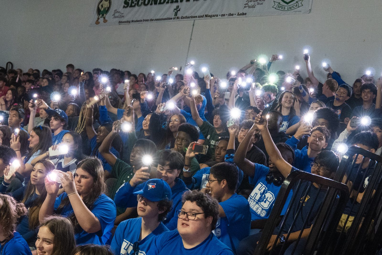 Crowd raising phone flashlights during an evening event