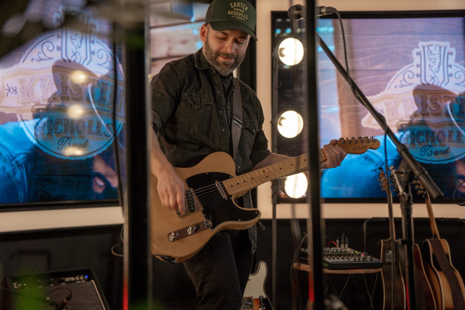 Guitarist performing on a lit production set